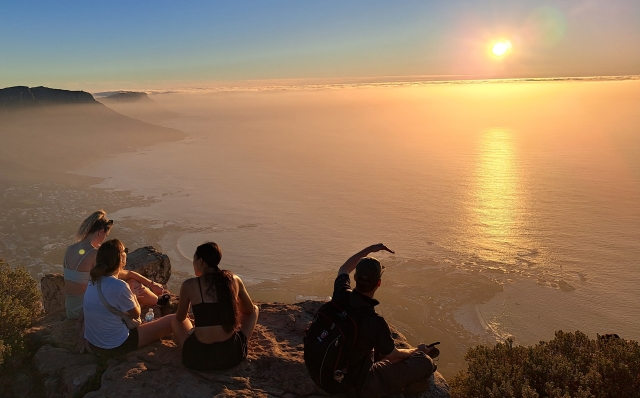 Group of people enjoying sunset from the top of Lions Head